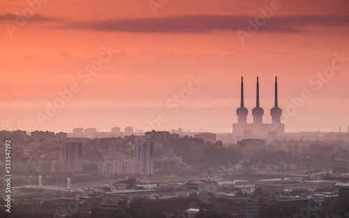 Vista aérea de la ciudad de Barcelona al amanecer con el mar al fondo. 