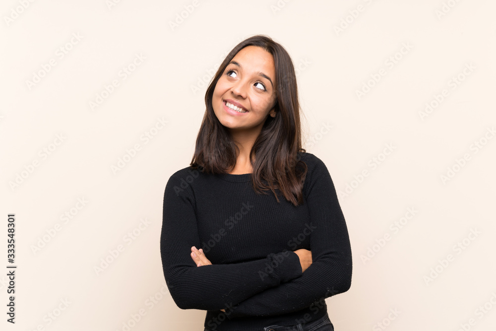 Young brunette woman with white sweater over isolated background looking up while smiling Young brunette woman with white sweater over isolated background looking up while smiling