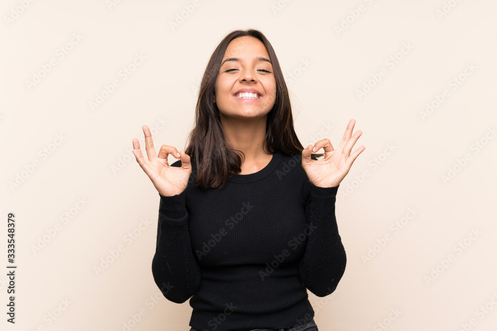 Young brunette woman with white sweater over isolated background in zen pose Young brunette woman with white sweater over isolated background in zen pose