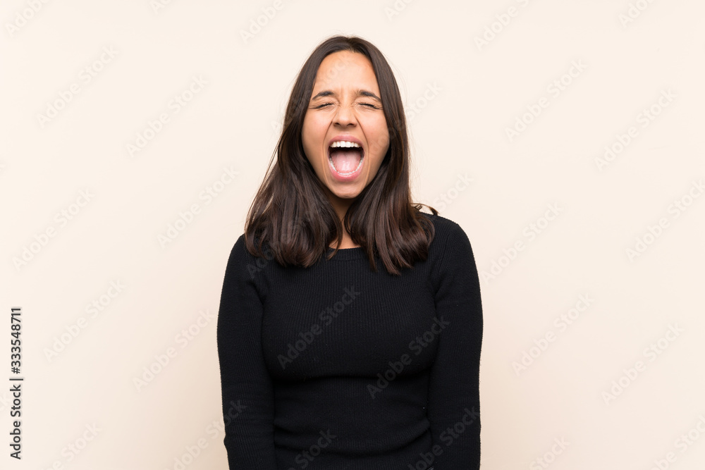 Young brunette woman with white sweater over isolated background shouting to the front with mouth wide open Young brunette woman with white sweater over isolated background shouting to the front with mouth wide open