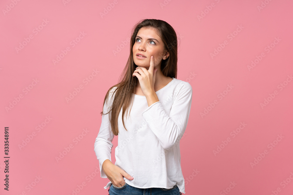 Young woman over isolated pink background thinking an idea while looking up Young woman over isolated pink background thinking an idea while looking up