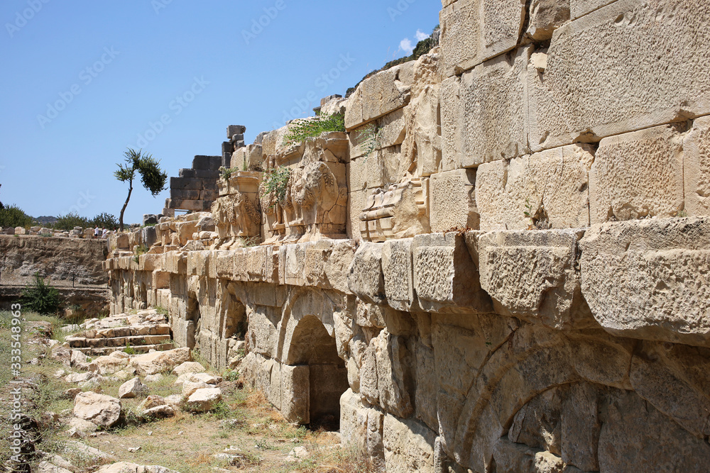 Ancient walls with arches and carvings on the surface of the stone, part of the antique amphitheater.
