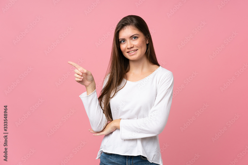 Young woman over isolated pink background pointing finger to the side Young woman over isolated pink background pointing finger to the side