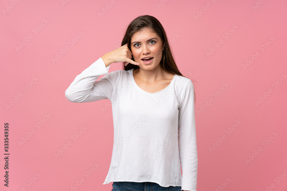 Young woman over isolated pink background making phone gesture. Call me back sign Young woman over isolated pink background making phone gesture. Call me back sign