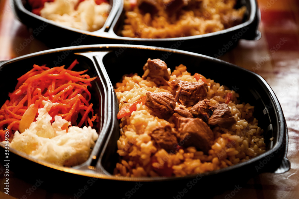 hot dish of meat and vegetables,with a side dish in a disposable container,for delivery of food at home hot dish of meat and vegetables,with a side dish in a disposable container,for delivery of food at home