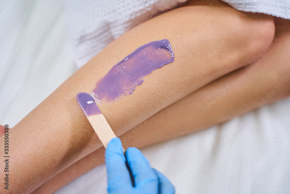 Close up of leg being covered with wax Close up of leg being covered with wax