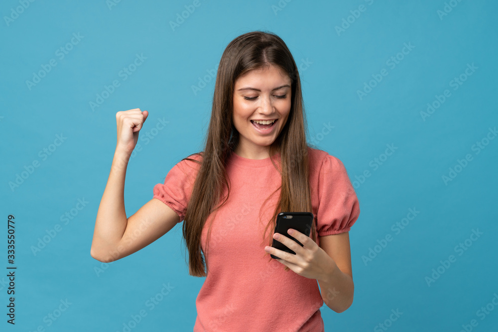 Young woman over isolated blue background using mobile phone Young woman over isolated blue background using mobile phone