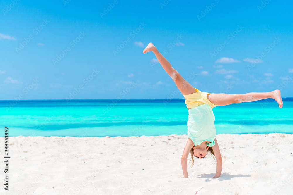 Adorable little girl have fun at tropical beach during vacation Adorable little girl have fun at tropical beach during vacation