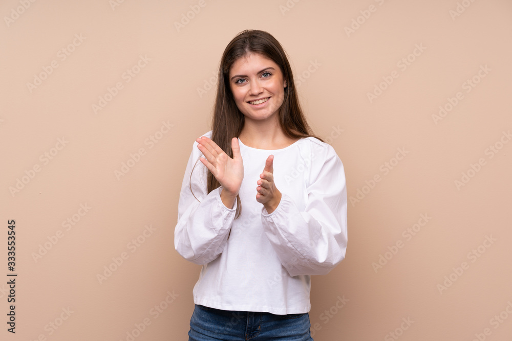 Young girl over isolated background applauding after presentation in a conference Young girl over isolated background applauding after presentation in a conference