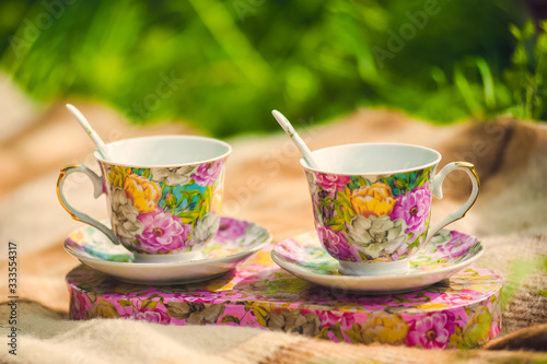 Two decorated cups with spoons