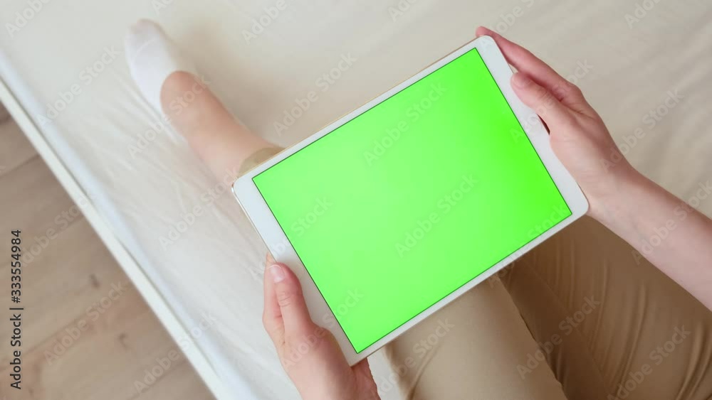 Woman with a tablet computer in hands with a green screen, chroma key. Woman with a tablet computer in hands with a green screen, chroma key.