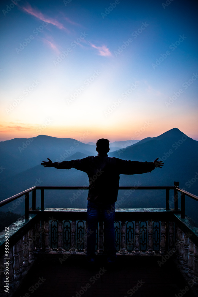 Fototapeta premium silhouette of a man standing at sunrise - Bisle Ghat KA India