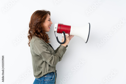 Young Russian woman over isolated white background shouting through a megaphone