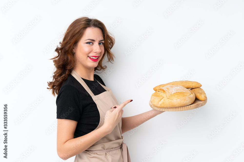 Woman in chef uniform. Female baker holding a table with several breads and pointing it Woman in chef uniform. Female baker holding a table with several breads and pointing it
