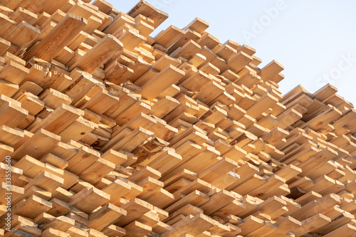Wooden boards  lumber  industrial wood  timber. Pine wood timber stack of natural rough wooden boards on building site. Industrial timber building materials