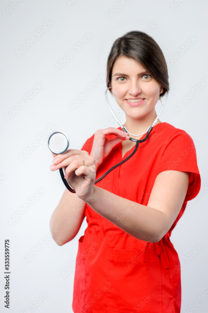 Female attractive doctor in red form with mask and stethoscope standing on white , Ambulance Female attractive doctor in red form with mask and stethoscope standing on white , Ambulance