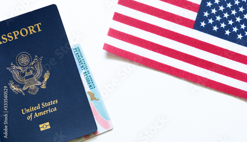 Fotografija American passport with permanent resident card (green card) and United States flag on white background