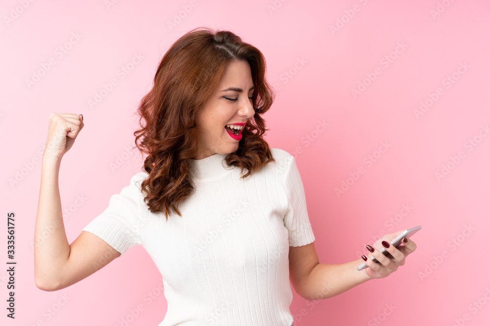 Young Russian woman over isolated pink background using mobile phone Young Russian woman over isolated pink background using mobile phone