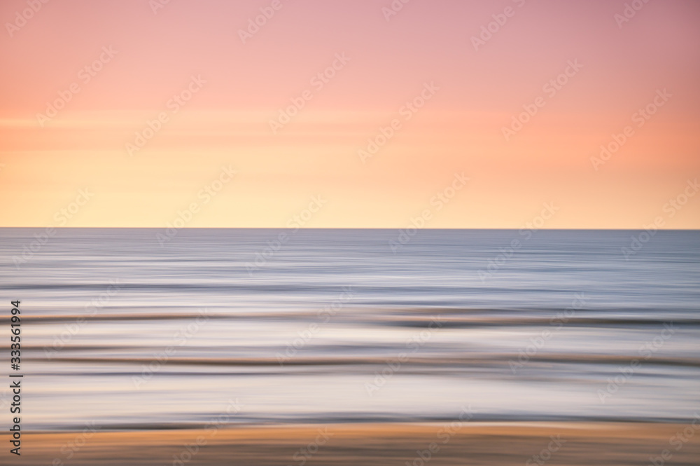 abstract landscape of sea. texture water, sky and sand in blurry motion in tropical sunset colors.