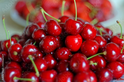 A plate filled with ripe red cherries.