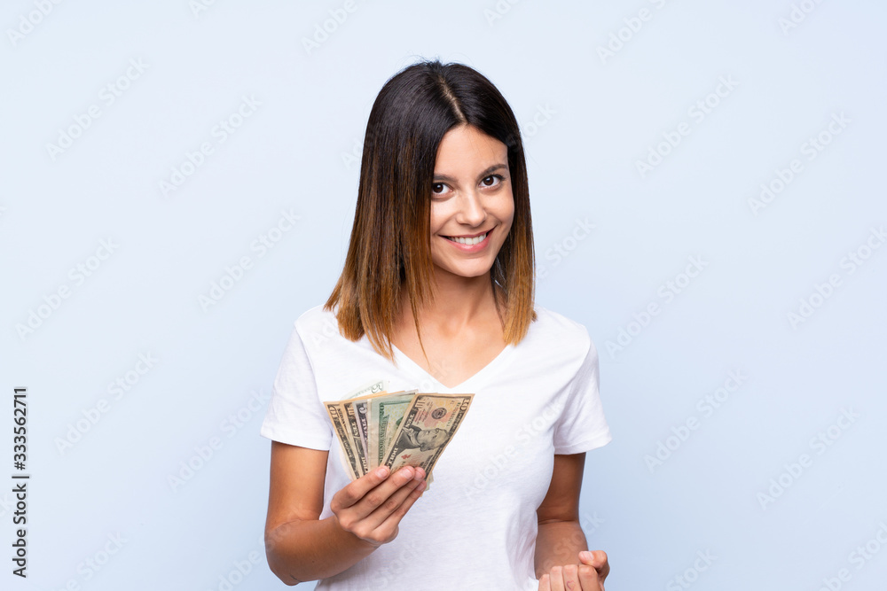 Young woman over isolated blue background taking a lot of money Young woman over isolated blue background taking a lot of money