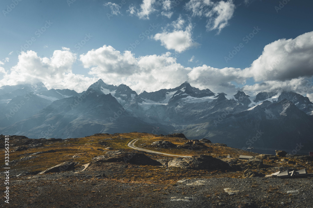 Beautiful Landscape Photo of Alpine Mountains in Switzerland Covered with Snow in the Summer in Zermatt, Switzerland on a warm sunny day 