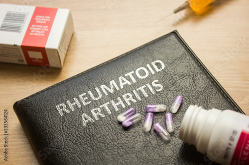 Book about Rheumatoid Arthritis and medication, injection, syringe and pills