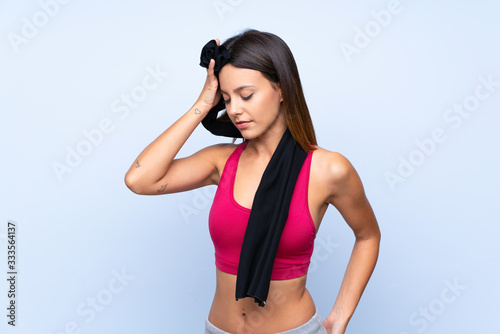 Young sport woman over isolated blue background with sport towel