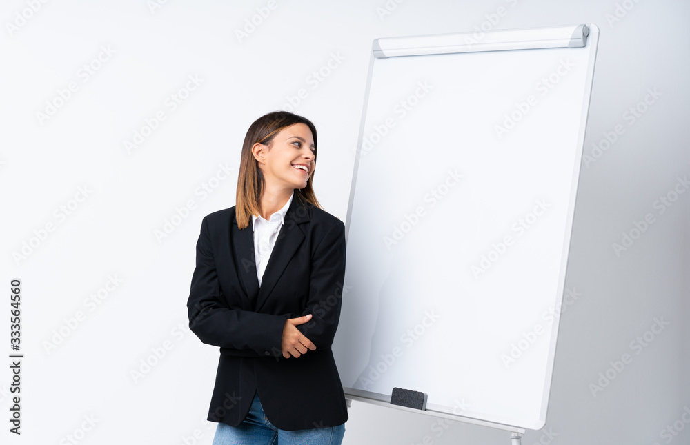 Young woman giving a presentation on white board looking side Young woman giving a presentation on white board looking side