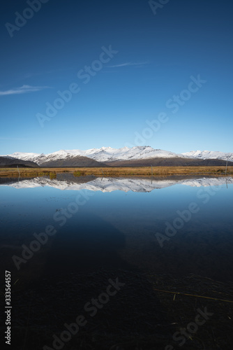 Snow Covered Mountain Landscape in Iceland with reflection in the water 