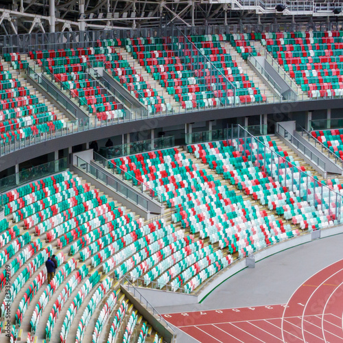 Empty multi-colored plastic seats with numbers and a piece of sports arena at the stadium. Sport concept.