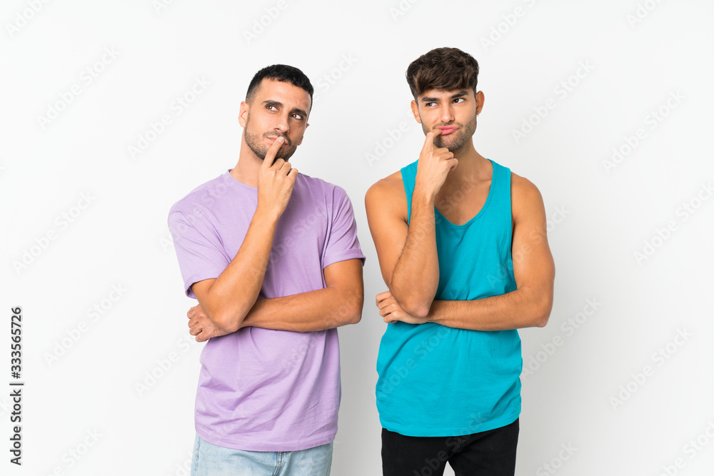 Two men over isolated background having doubts while looking up Two men over isolated background having doubts while looking up