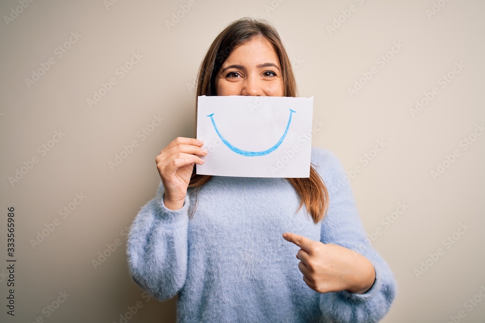Young blonde woman holding funny smile drawing on mouth as happy expression with surprise face pointing finger to himself Young blonde woman holding funny smile drawing on mouth as happy expression with surprise face pointing finger to himself