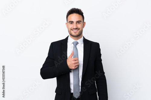 Young business man over isolated background giving a thumbs up gesture