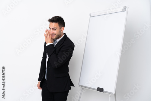 Young man giving a presentation on white board and whispering something © luismolinero