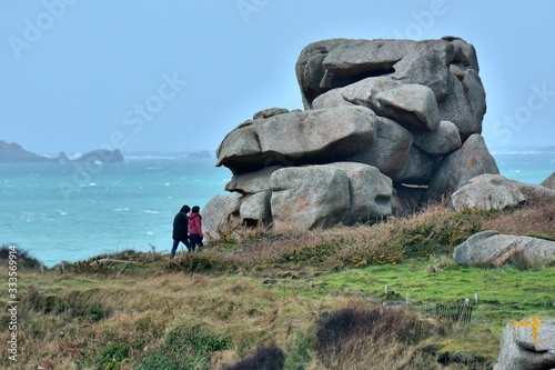 People walking on the path of the pink granite coast in Brittany. France