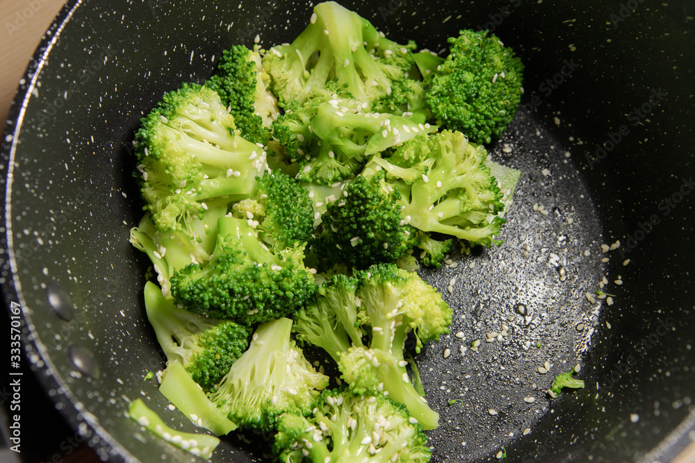 Steamed broccoli with sesame seed on the pan.