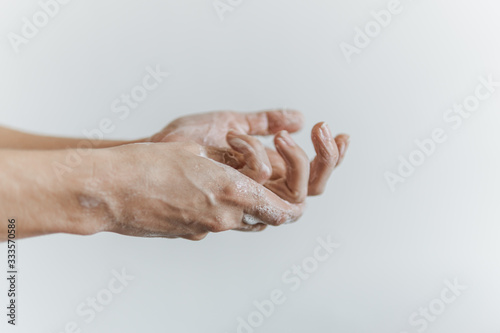 Detalhe de mãos femininas com espuma de sabonete. Lavar as mãos para combater o coronavírus. photo