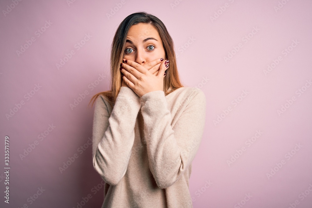 Beautiful blonde woman with blue eyes wearing turtleneck sweater over pink background shocked covering mouth with hands for mistake. Secret concept. Beautiful blonde woman with blue eyes wearing turtleneck sweater over pink background shocked covering mouth with hands for mistake. Secret concept.