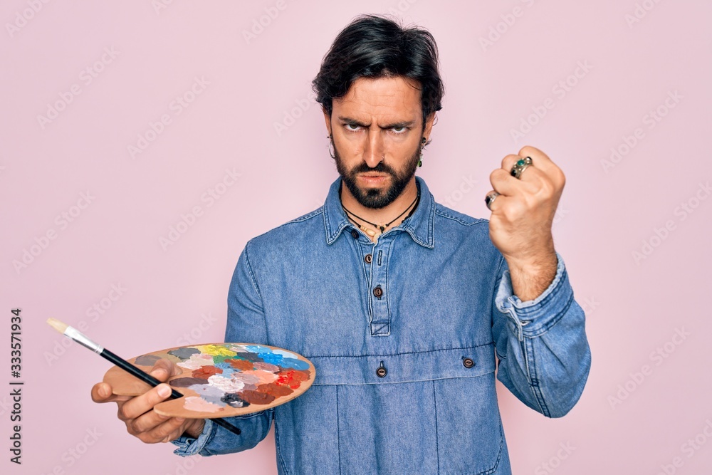 Young handsome hispanic artist man with bear holding painter palette and paintbrush annoyed and frustrated shouting with anger, crazy and yelling with raised hand, anger concept Young handsome hispanic artist man with bear holding painter palette and paintbrush annoyed and frustrated shouting with anger, crazy and yelling with raised hand, anger concept