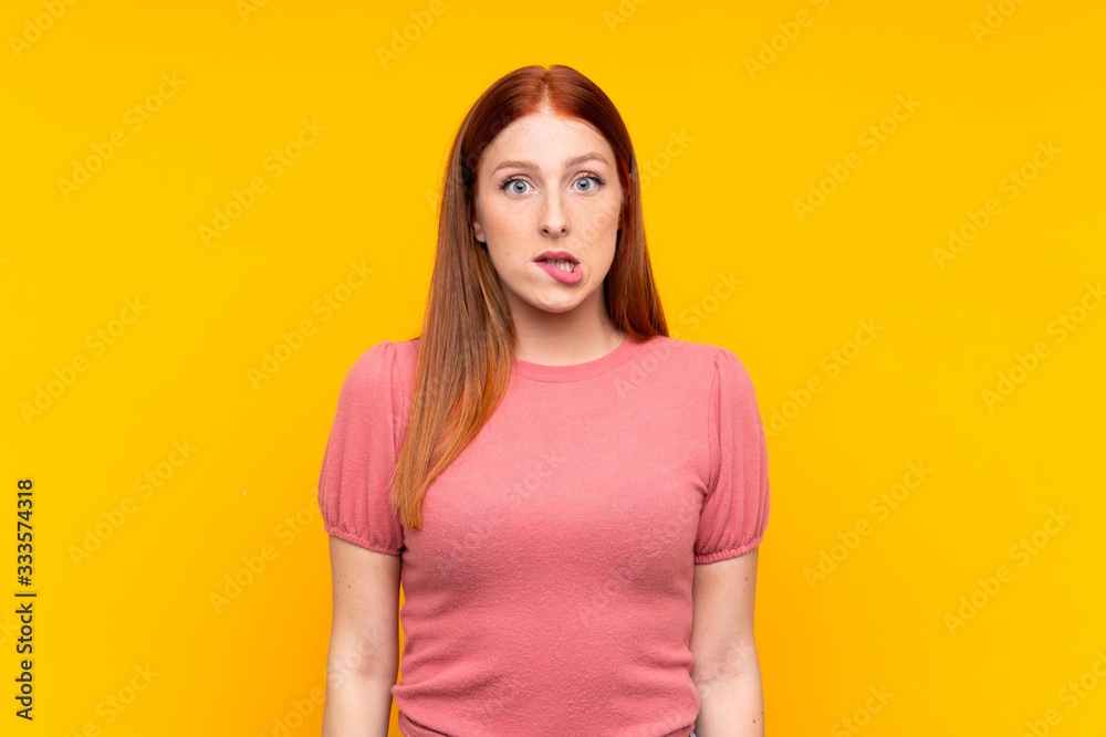 Young redhead woman over isolated yellow background having doubts and with confuse face expression Young redhead woman over isolated yellow background having doubts and with confuse face expression