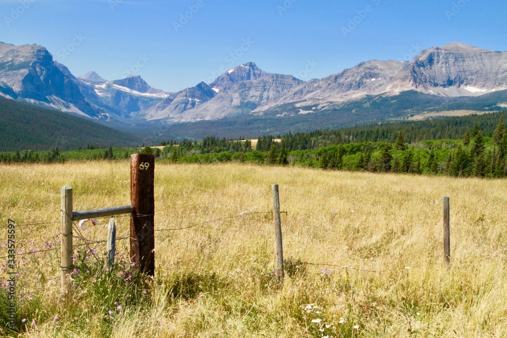 Dry grass field with fence set among the mountains of Montana. Dry grass field with fence set among the mountains of Montana.