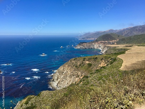 California coastline south of Monterey with a brilliant blue Pacific Ocean and sharp cliffs. 