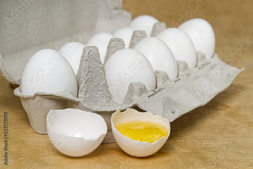 Paper Egg Tray with white eggs. chicken white eggs close up. beige background. broken chicken white egg.