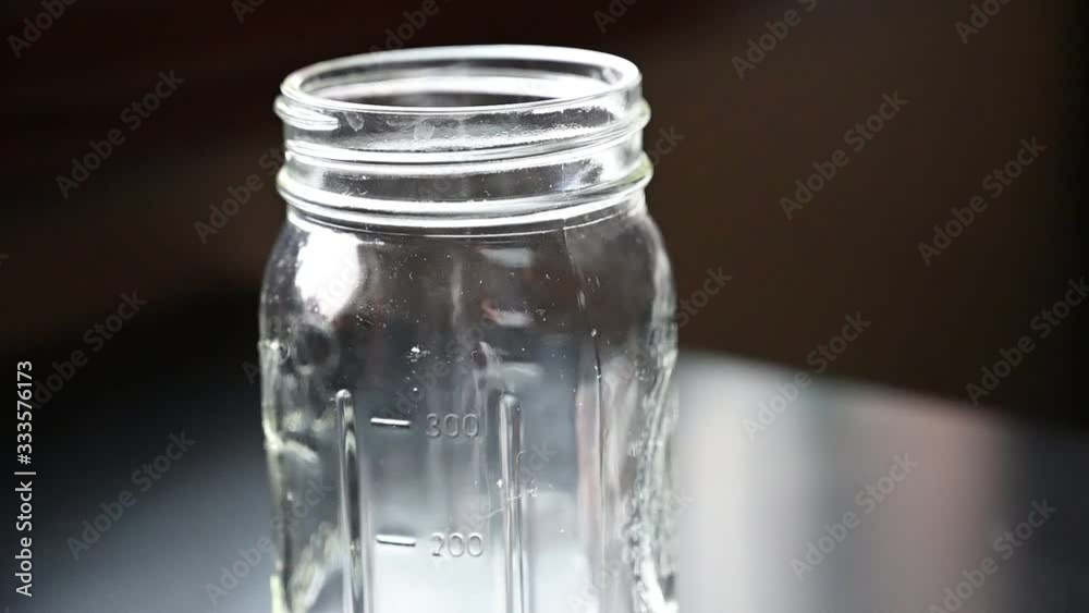 Slow motion of dropping coins into a glass jar Slow motion of dropping coins into a glass jar