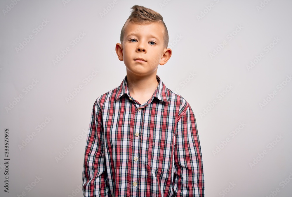 Young little caucasian kid with blue eyes wearing elegant shirt standing over isolated background Relaxed with serious expression on face. Simple and natural looking at the camera. Young little caucasian kid with blue eyes wearing elegant shirt standing over isolated background Relaxed with serious expression on face. Simple and natural looking at the camera.