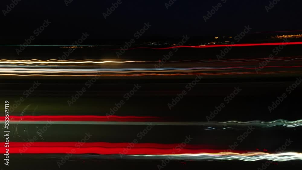 Abstract side view of car light trails moving fast at night time lapse