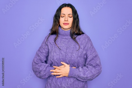 Photos Young beautiful woman wearing casual turtleneck sweater standing over purple background with hand on stomach because indigestion, painful illness feeling unwell