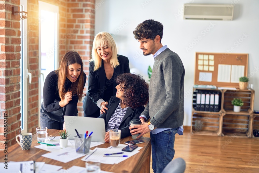Group of business workers smiling happy and confident. Working together with smile on face using laptop at the office Group of business workers smiling happy and confident. Working together with smile on face using laptop at the office
