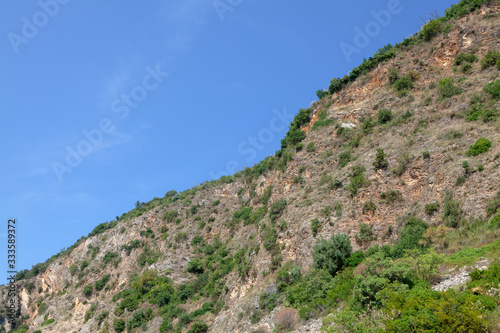 green cliff against blue sky